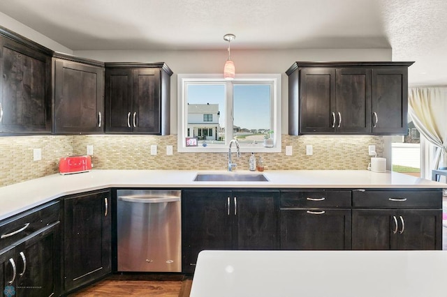 kitchen with dishwasher, dark wood finished floors, tasteful backsplash, and a sink
