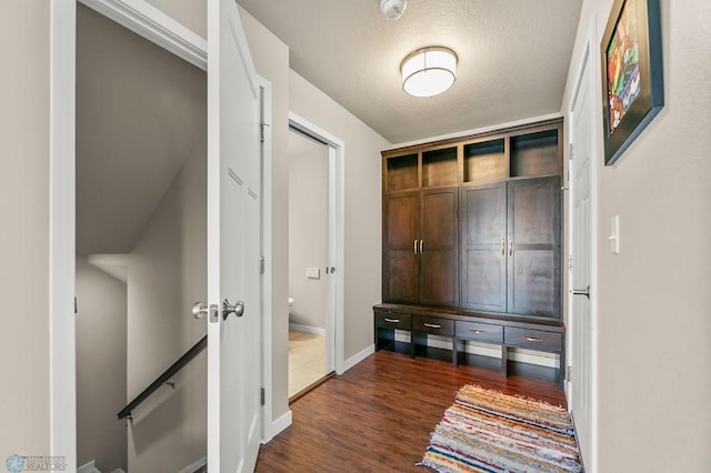 mudroom featuring dark wood finished floors and baseboards