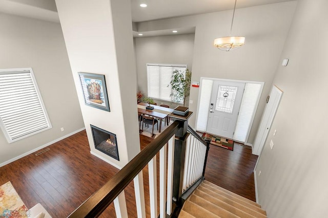 entryway featuring recessed lighting, baseboards, stairs, a towering ceiling, and wood finished floors