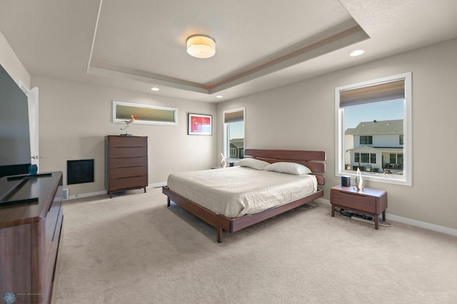 bedroom with multiple windows, light carpet, a tray ceiling, and recessed lighting