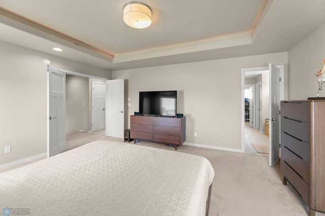 bedroom with a tray ceiling, light carpet, baseboards, and recessed lighting