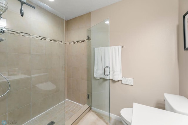 bathroom featuring toilet and a stall shower