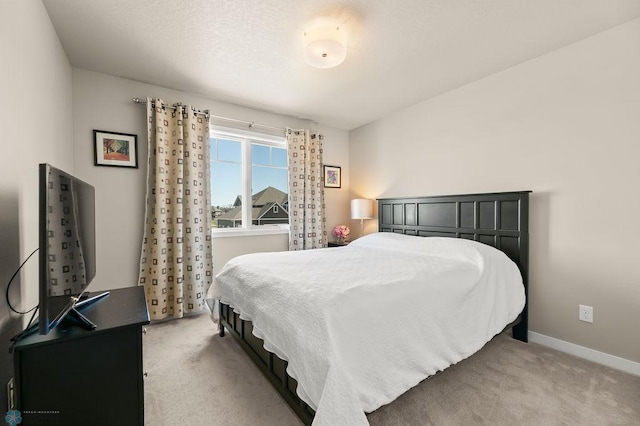 bedroom featuring baseboards and light carpet