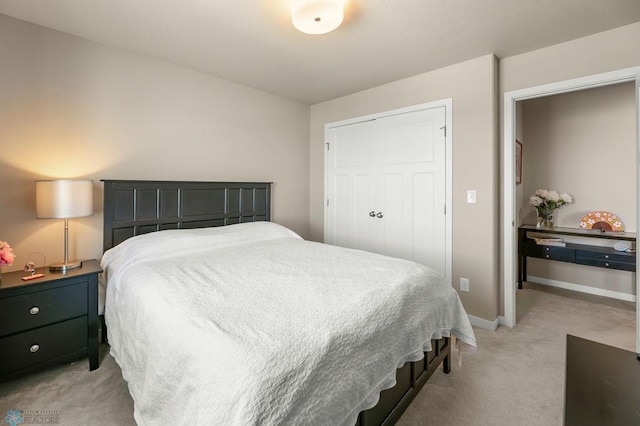 bedroom featuring light colored carpet, a closet, and baseboards