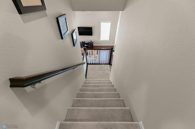 stairway featuring a textured wall