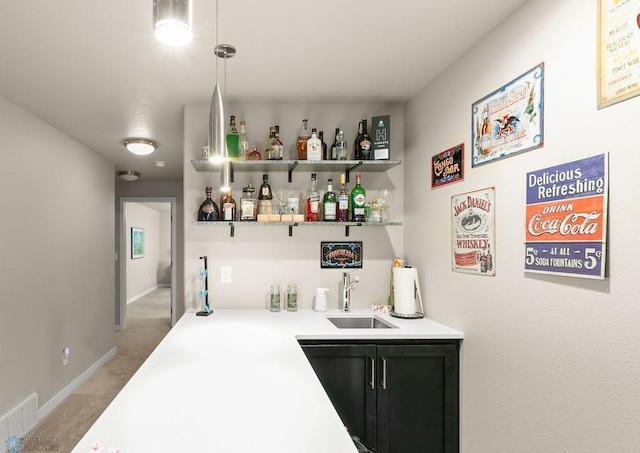 bar with a sink, wet bar, visible vents, light carpet, and baseboards