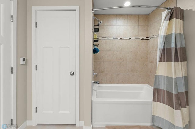 full bathroom featuring shower / bath combination with curtain and baseboards