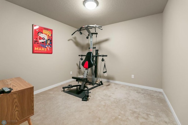 exercise area with a textured ceiling, baseboards, and carpet floors