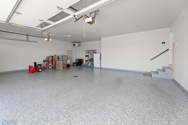 garage with freestanding refrigerator, baseboards, and a garage door opener
