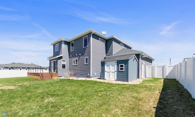 back of house with a fenced backyard, a wooden deck, and a yard