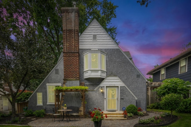 4904 11th Ave S, Minneapolis, MN 55417 - view of front of house featuring a chimney, a patio, and stucco siding