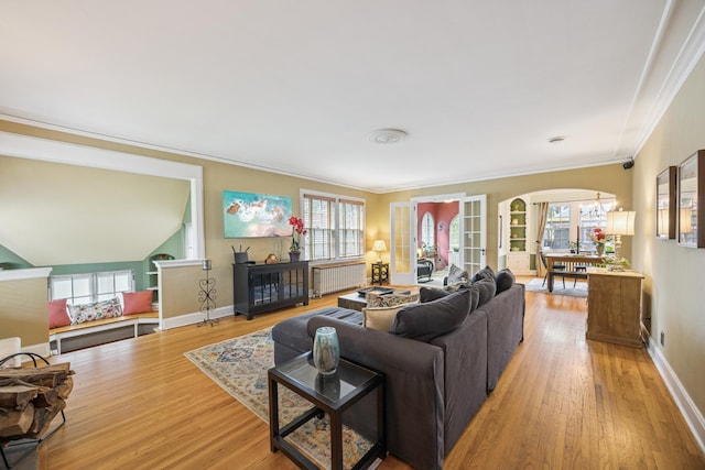 4904 11th Ave S, Minneapolis, MN 55417 - living room with arched walkways, radiator, light wood-type flooring, crown molding, and plenty of natural light