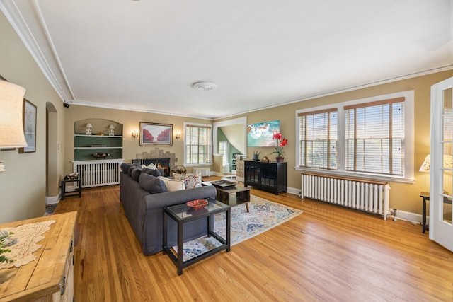 4904 11th Ave S, Minneapolis, MN 55417 - living area featuring radiator, a lit fireplace, ornamental molding, wood finished floors, and plenty of natural light