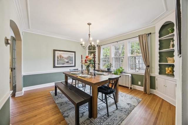 4904 11th Ave S, Minneapolis, MN 55417 - dining area with radiator, crown molding, arched walkways, a chandelier, and light wood-style flooring