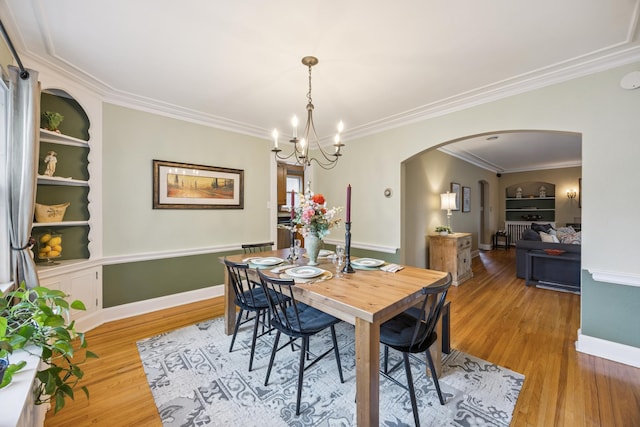 4904 11th Ave S, Minneapolis, MN 55417 - dining room with arched walkways, light wood-type flooring, ornamental molding, a chandelier, and built in shelves