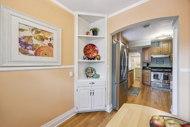 4904 11th Ave S, Minneapolis, MN 55417 - kitchen featuring appliances with stainless steel finishes, arched walkways, under cabinet range hood, light wood-type flooring, and built in shelves
