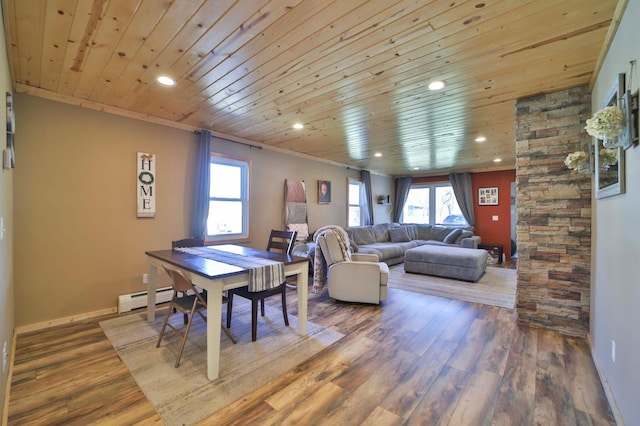interior space with recessed lighting, plenty of natural light, baseboard heating, and wood finished floors
