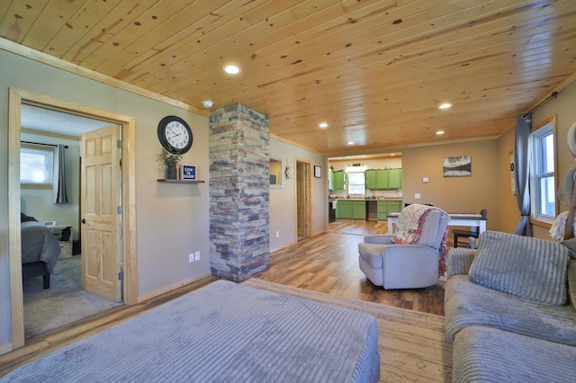 living room featuring decorative columns, wood ceiling, and wood finished floors