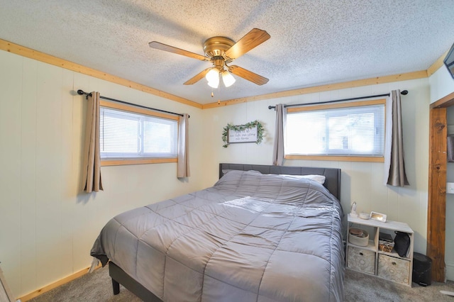carpeted bedroom featuring a ceiling fan and a textured ceiling