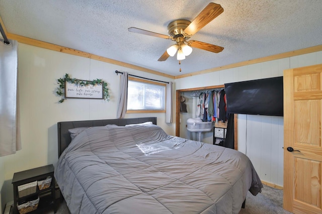 carpeted bedroom featuring a closet, a ceiling fan, and a textured ceiling