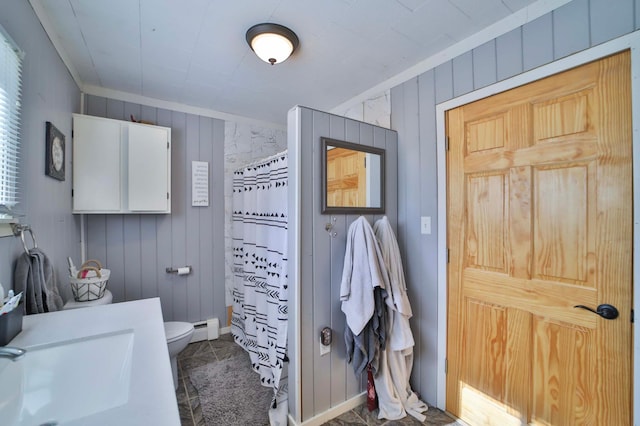 full bathroom with a shower with curtain, crown molding, baseboard heating, wood walls, and toilet
