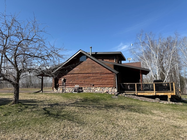 view of side of home with a wooden deck and a lawn