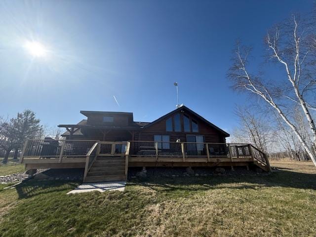 back of property featuring a lawn, a deck, and stairs