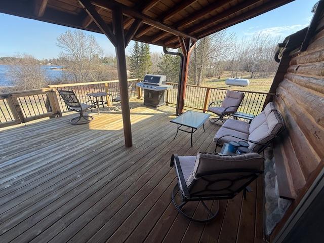 deck featuring a water view and a grill