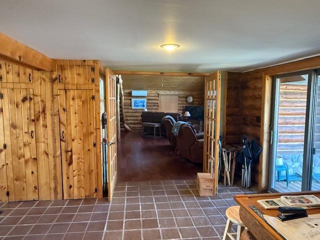 hallway with tile patterned flooring and log walls