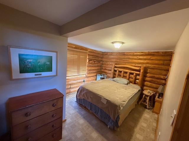 bedroom with carpet flooring and rustic walls