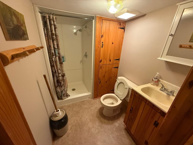bathroom featuring toilet, vanity, and a shower stall