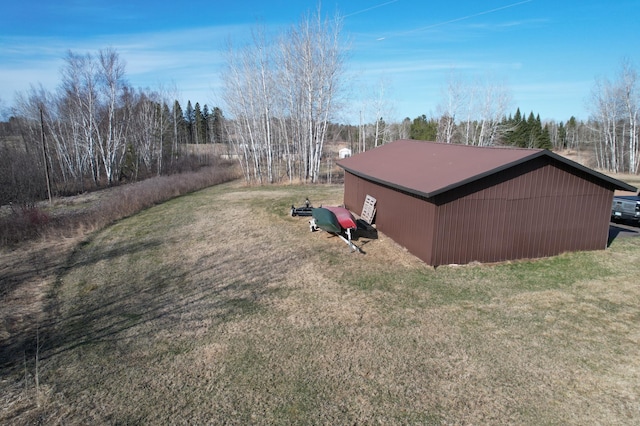 view of side of home with an outdoor structure, a pole building, and a yard