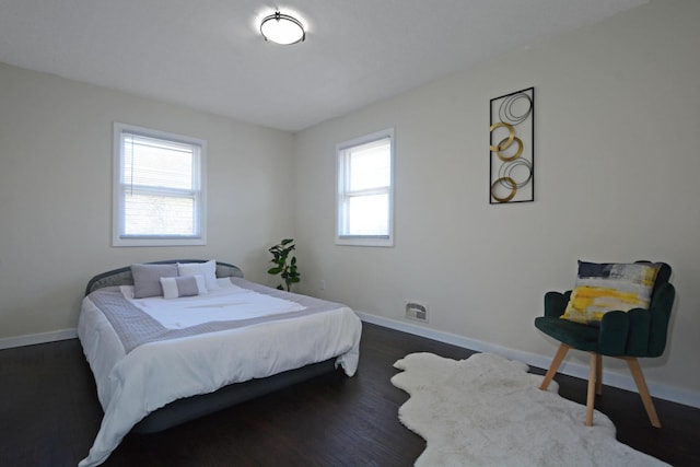 bedroom with baseboards and dark wood finished floors
