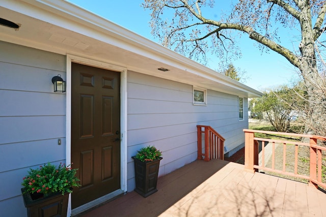 view of exterior entry featuring a wooden deck