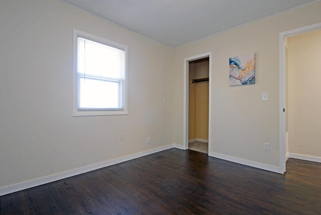unfurnished bedroom featuring baseboards and dark wood finished floors