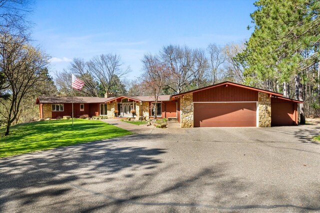 1206 Pinecrest Ln, New Richmond, WI 54017 - mid-century inspired home with stone siding, a garage, driveway, and a front yard
