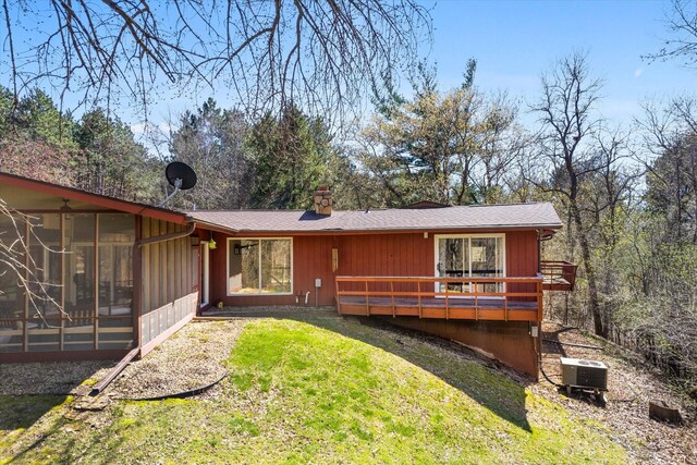 1206 Pinecrest Ln, New Richmond, WI 54017 - view of front of house with a sunroom, cooling unit, a front lawn, a chimney, and a wooden deck