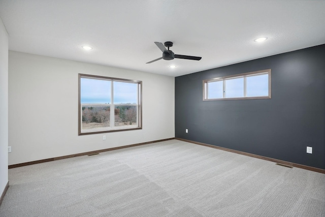 spare room with recessed lighting, a ceiling fan, visible vents, baseboards, and light colored carpet