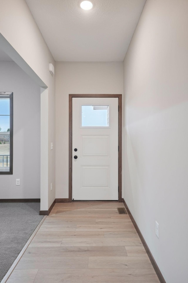 entryway featuring visible vents, light wood-style flooring, and baseboards