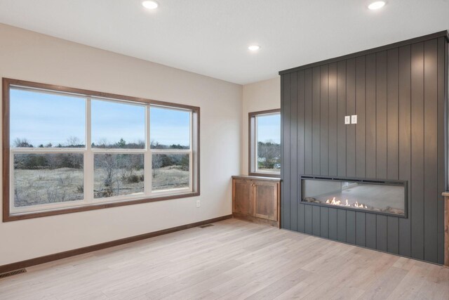 unfurnished living room with a large fireplace, visible vents, recessed lighting, and light wood-style flooring