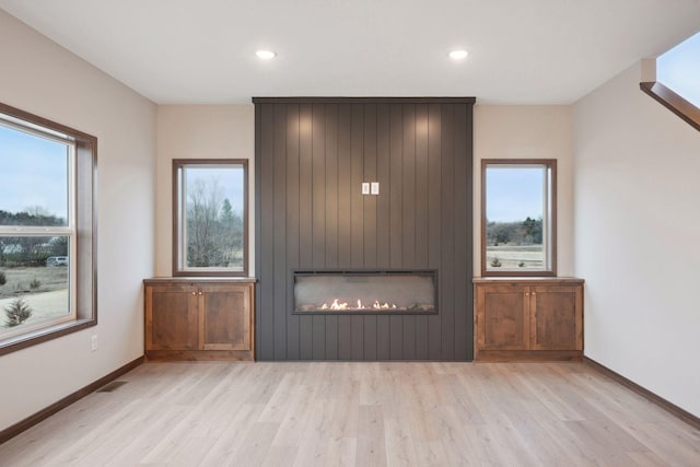 unfurnished living room featuring a large fireplace, wood finished floors, and recessed lighting