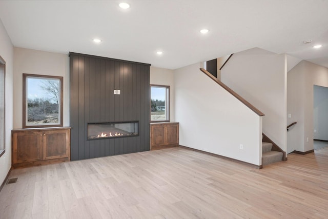 unfurnished living room with visible vents, wood finished floors, a healthy amount of sunlight, and recessed lighting