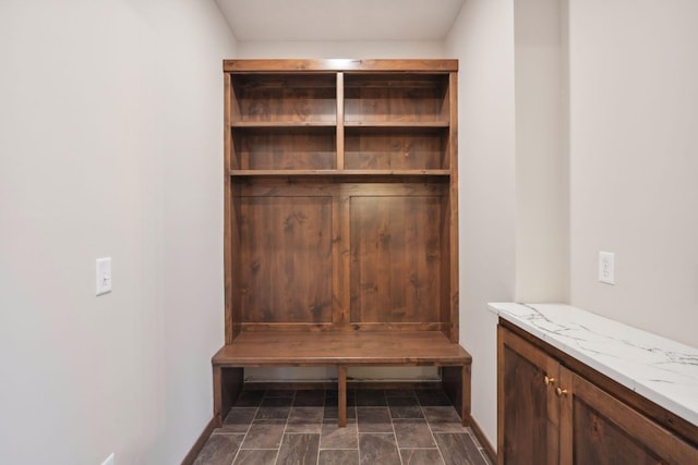 mudroom featuring baseboards and stone finish floor