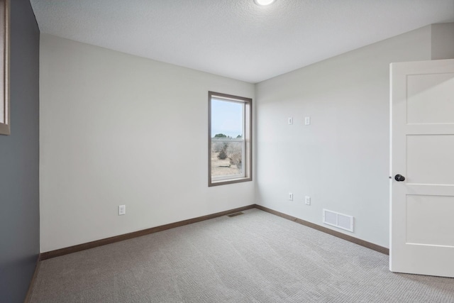 unfurnished room featuring baseboards, visible vents, carpet floors, and a textured ceiling
