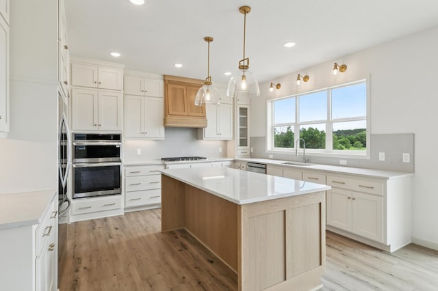 21959 Edison Ct NW, East Bethel, MN 55011 - kitchen featuring stainless steel appliances, tasteful backsplash, light wood-type flooring, custom range hood, and recessed lighting
