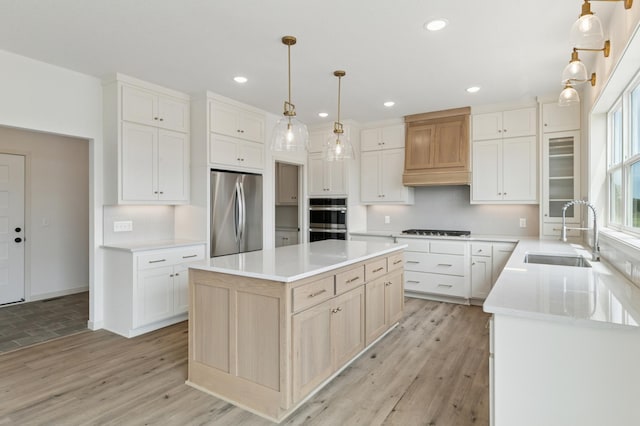 21959 Edison Ct NW, East Bethel, MN 55011 - kitchen with stainless steel appliances, a center island, light wood-type flooring, light countertops, and recessed lighting