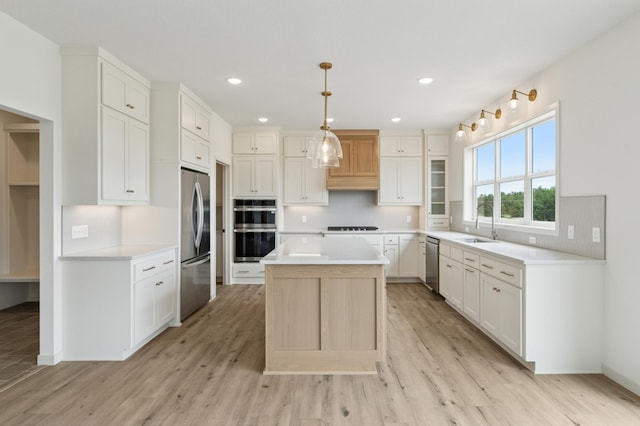 21959 Edison Ct NW, East Bethel, MN 55011 - kitchen with stainless steel appliances, a center island, light wood-style flooring, backsplash, and recessed lighting