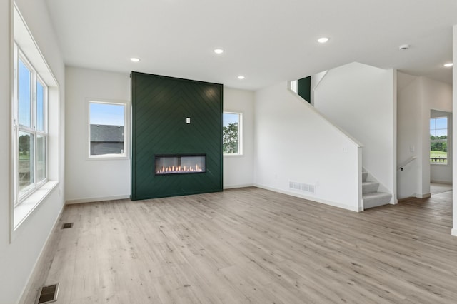 21959 Edison Ct NW, East Bethel, MN 55011 - unfurnished living room with wood finished floors, recessed lighting, stairs, and a fireplace