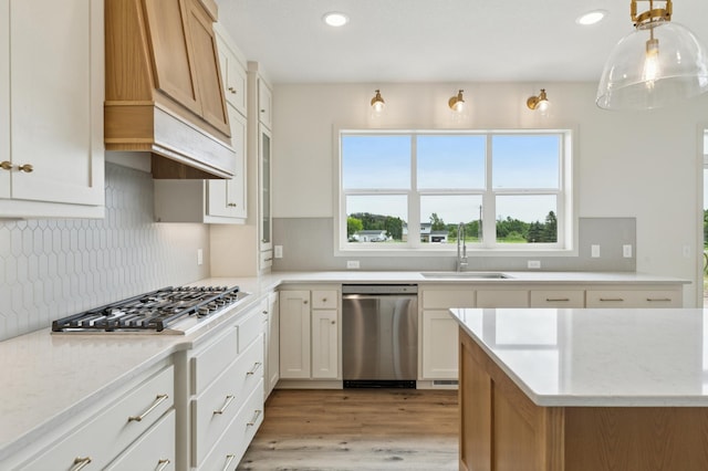 21959 Edison Ct NW, East Bethel, MN 55011 - kitchen with stainless steel appliances, light wood-style flooring, recessed lighting, tasteful backsplash, and custom exhaust hood