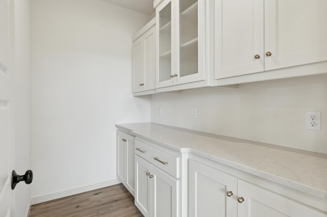 21959 Edison Ct NW, East Bethel, MN 55011 - kitchen with light wood finished floors, white cabinets, and glass insert cabinets